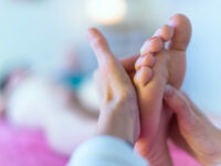 Therapist's hands massaging female foot
